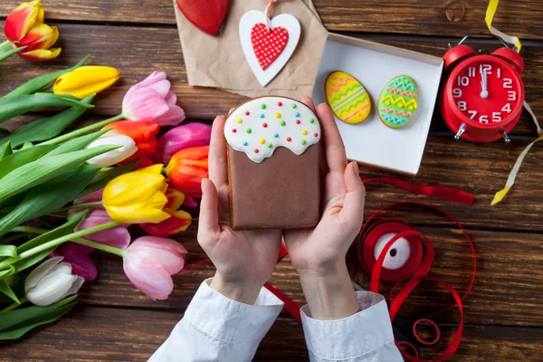 Vrouwelijke handen houden een cookie Pasen — Stockfoto