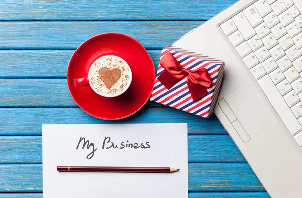 Papier-, cadeau-, koffie- en laptop liggend op de tafel — Stockfoto