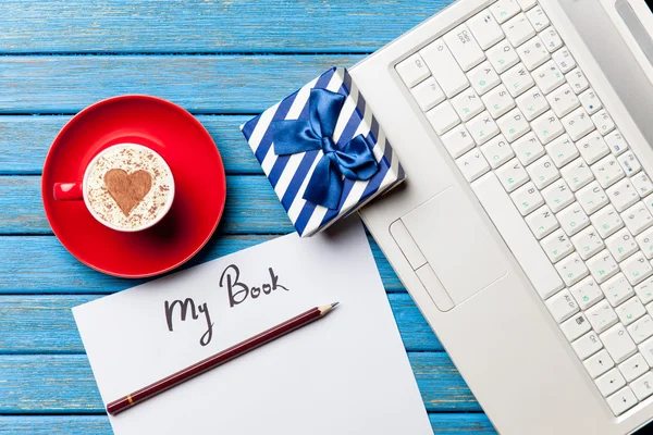 Papel, presente, café e laptop deitado sobre a mesa — Fotografia de Stock