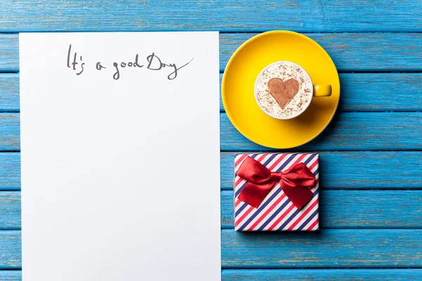 Papier, prezent, kawy i laptop leżący na stole — Zdjęcie stockowe
