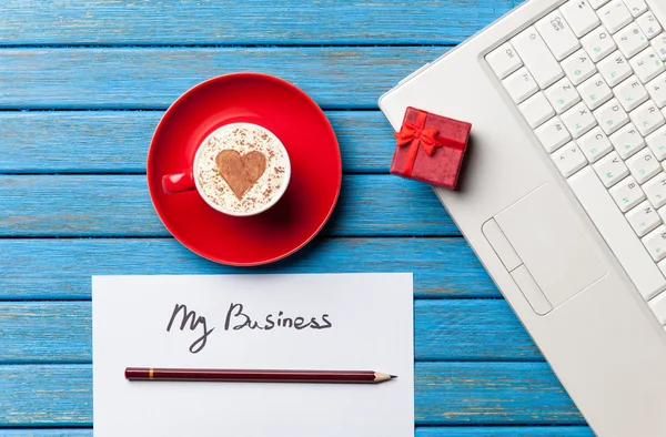 Papier-, cadeau-, koffie- en laptop liggend op de tafel — Stockfoto