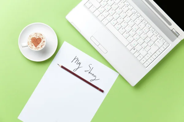 Xícara de café e laptop deitado na mesa — Fotografia de Stock