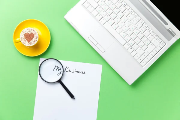 Vergrootglas en laptop liggend op de tafel — Stockfoto