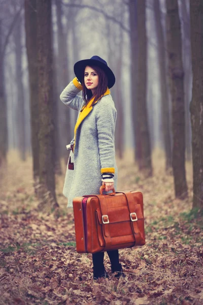 Porträt einer jungen Frau mit einem Koffer — Stockfoto