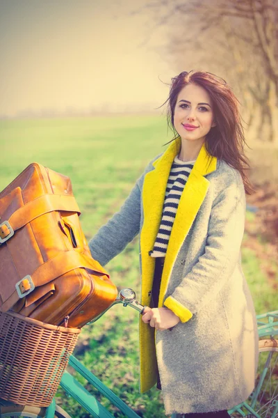 Porträt einer jungen Frau mit Fahrrad und Koffer — Stockfoto