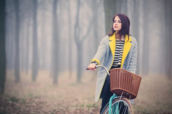 Retrato de uma jovem mulher com uma bicicleta — Fotografia de Stock
