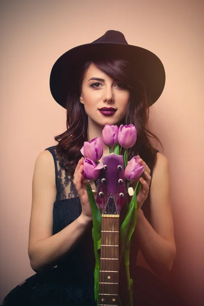 Portré egy gyönyörű fiatal nő, gitár és tulipán — Stock Fotó