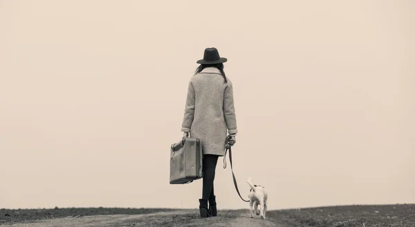 Young woman with suitcase and dog — Stock Photo, Image