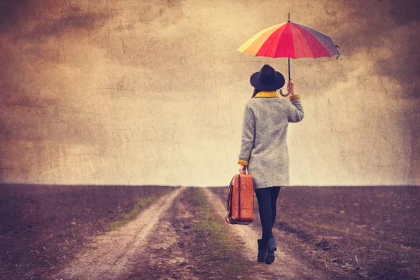 Portrait of a young woman with umbrella and suitcase — Stock Photo, Image