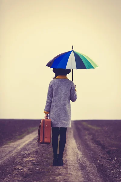 Vrouw met paraplu en koffer — Stockfoto