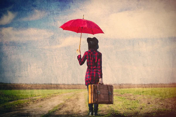 Frau mit Koffer und Regenschirm — Stockfoto