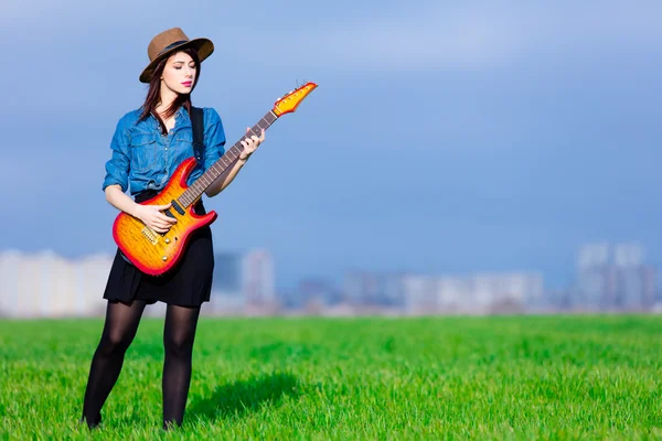 Портрет молодой женщины с гитарой — стоковое фото