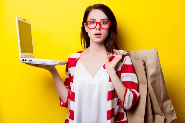 Retrato de la joven con bolsas de compras y portátil — Foto de Stock