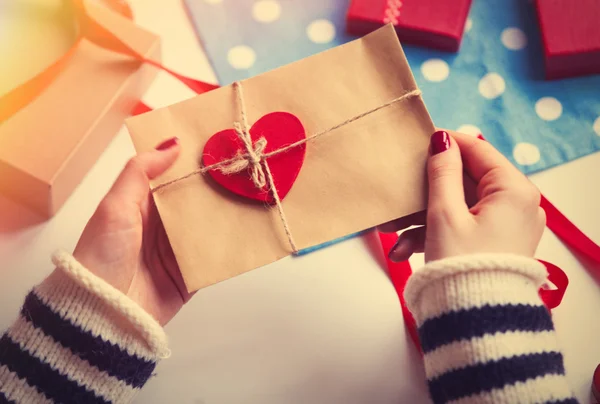 Woman preparing envelope and gift — Stock Photo, Image