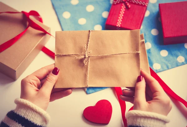 Femme préparant enveloppe et cadeau — Photo