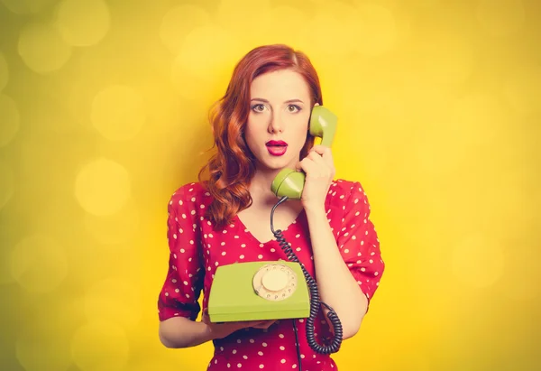 Girl in red dress with green dial phone — Stock Photo, Image