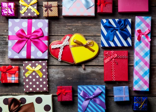 Regalos de colores y galletas en la mesa — Foto de Stock