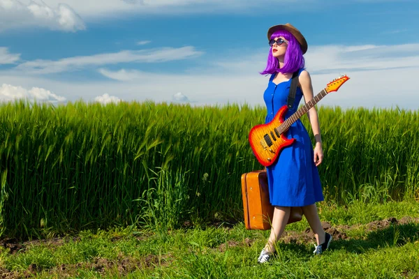 Giovane donna con valigia e chitarra — Foto Stock