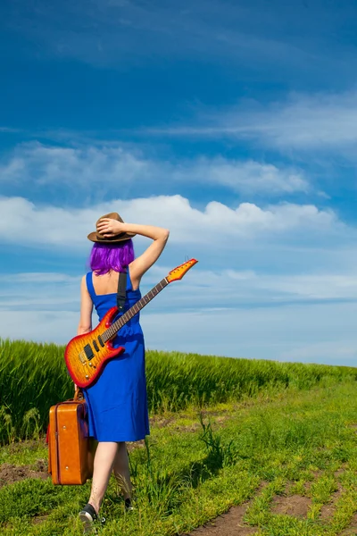 Young woman with suitcase and guitar — Stock Photo, Image