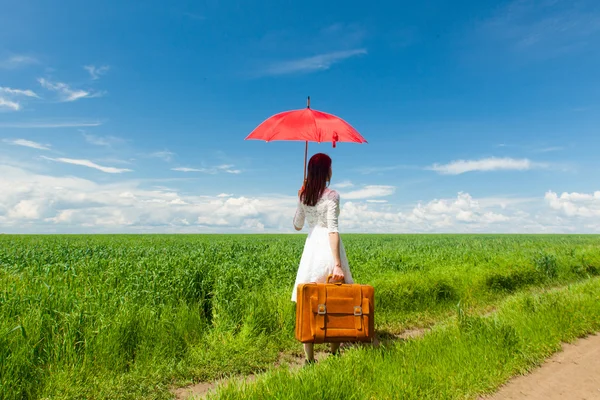 Młoda kobieta z walizką i parasol — Zdjęcie stockowe