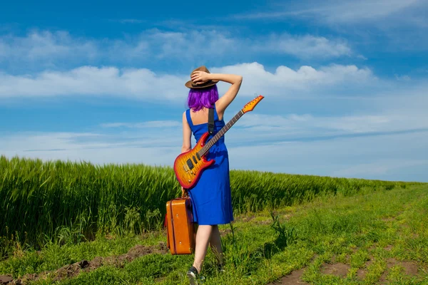 Giovane donna con valigia e chitarra — Foto Stock