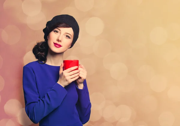 Frau im blauen Kleid mit roter Tasse — Stockfoto