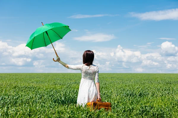 Jeune femme avec valise et parapluie — Photo