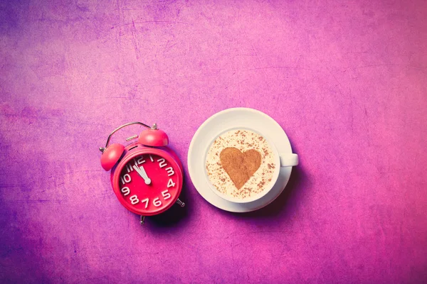 Kopje koffie en rode klok — Stockfoto