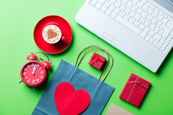 Cup, clock, gifts, shopping bag and laptop — Stock Photo, Image