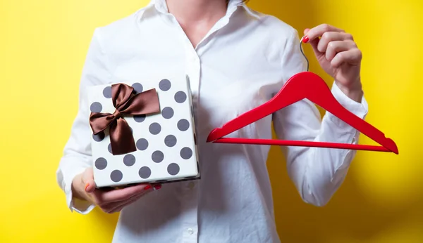 Jeune femme avec cintre et cadeau — Photo