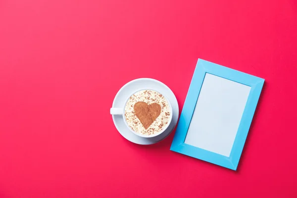 Cup and photo frame — Stock Photo, Image