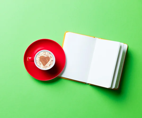 Cup of coffee and opened notebook — Stock Photo, Image