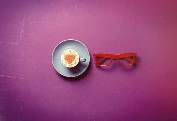 Blå kopp kaffe och glasögon — Stockfoto
