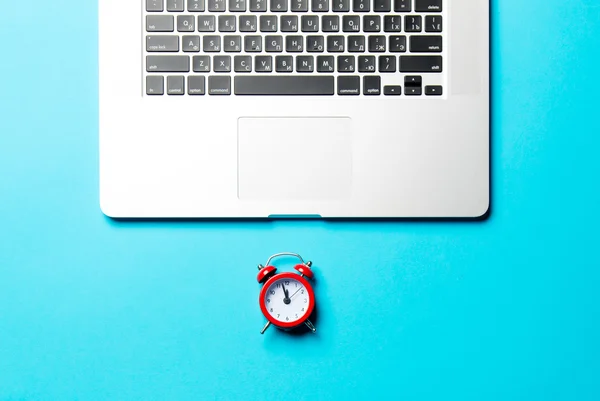 Rode klok en laptop — Stockfoto