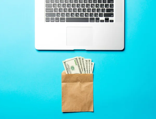 Деньги, конверт и ноутбук — стоковое фото