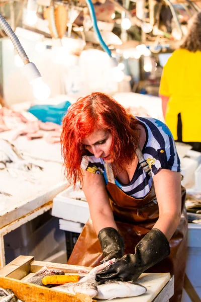 Mujer joven cortando el pescado Fotos de stock