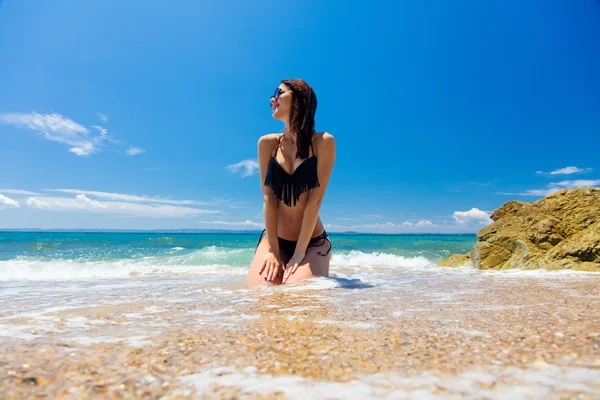 Kvinna som sitter på stranden — Stockfoto