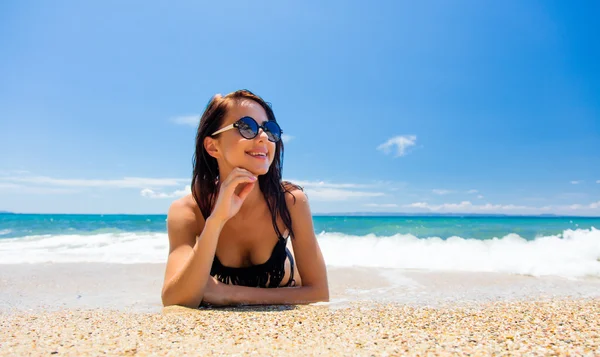 Jonge vrouw liggend op het strand — Stockfoto