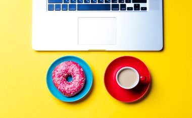 çörek, fincan kahve ve dizüstü