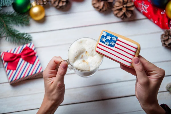 Vrouwelijke handen met een cookie en een kopje koffie — Stockfoto