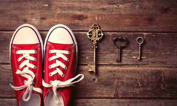 Sepatu karet merah dan kunci vintage yang berbeda — Stok Foto