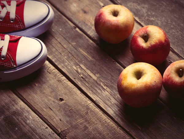 Pyszne jabłka i czerwone Półbuty gumowe — Zdjęcie stockowe