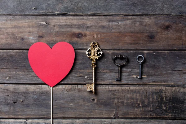 Juguete en forma de corazón rojo y diferentes llaves vintage — Foto de Stock