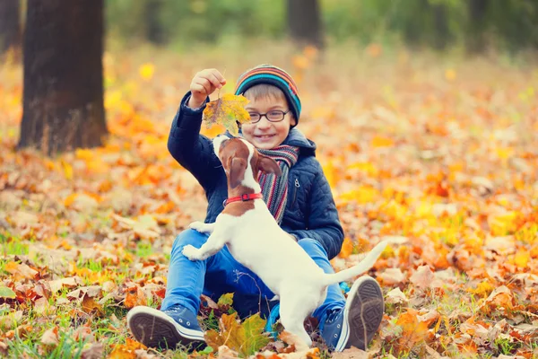 Menino brincando com seu cachorro bonito — Fotografia de Stock