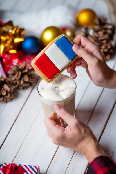 Vrouwelijke handen met een cookie en een kopje koffie — Stockfoto