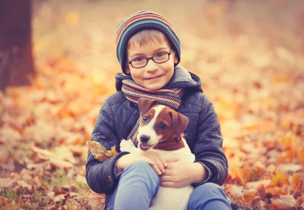 Menino brincando com seu cachorro bonito — Fotografia de Stock