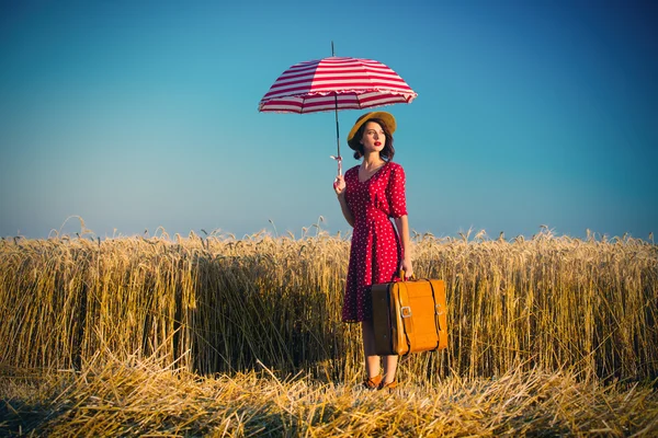 Jonge vrouw met paraplu en koffer — Stockfoto