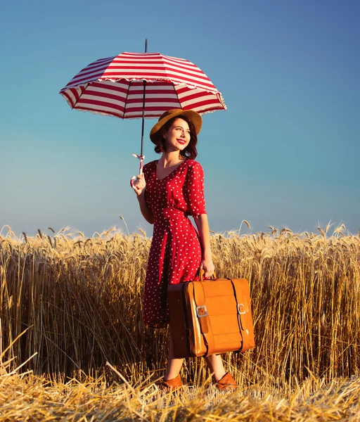 Jonge vrouw met paraplu en koffer — Stockfoto