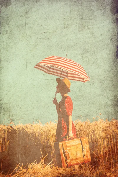 Jeune femme avec parapluie et valise — Photo