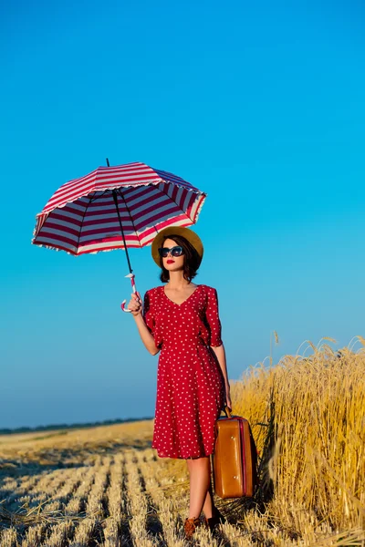 Jeune femme avec parapluie et valise — Photo